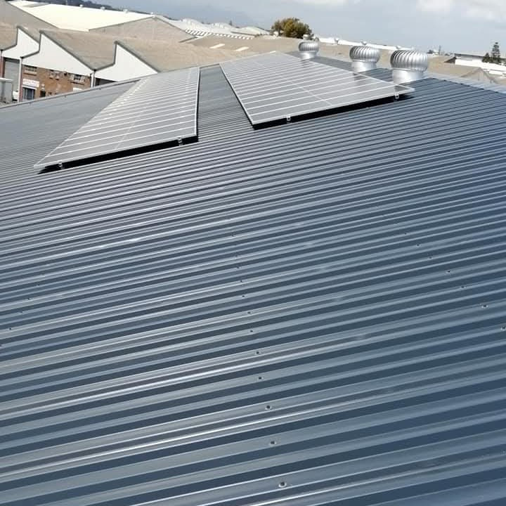 Bussey Roofs team installing metal roof sheeting in Cape Town